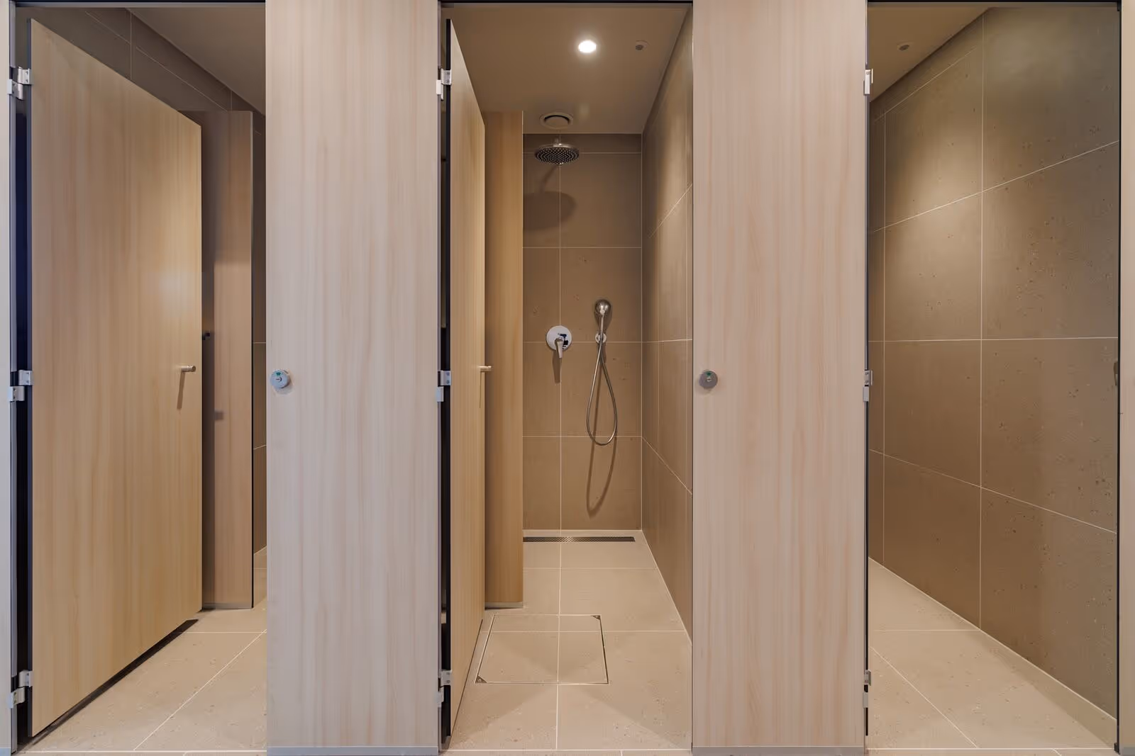 Moderne douchecabines met houten deuren in een sanitairgebouw van Camping Bijela Uvala