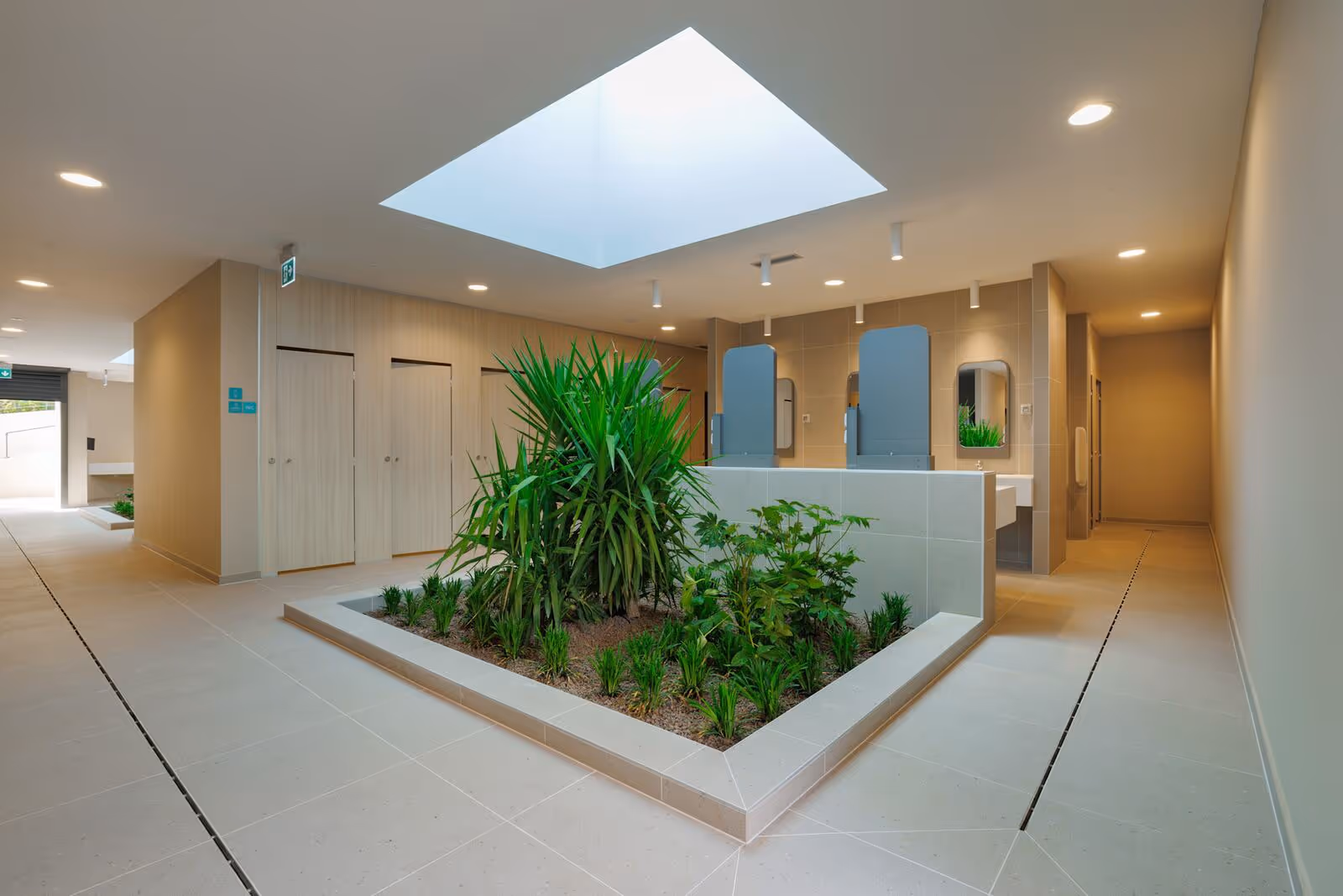 Entree van een sanitairgebouw met een groene binnentuin onder een daklicht, Camping Bijela Uvala