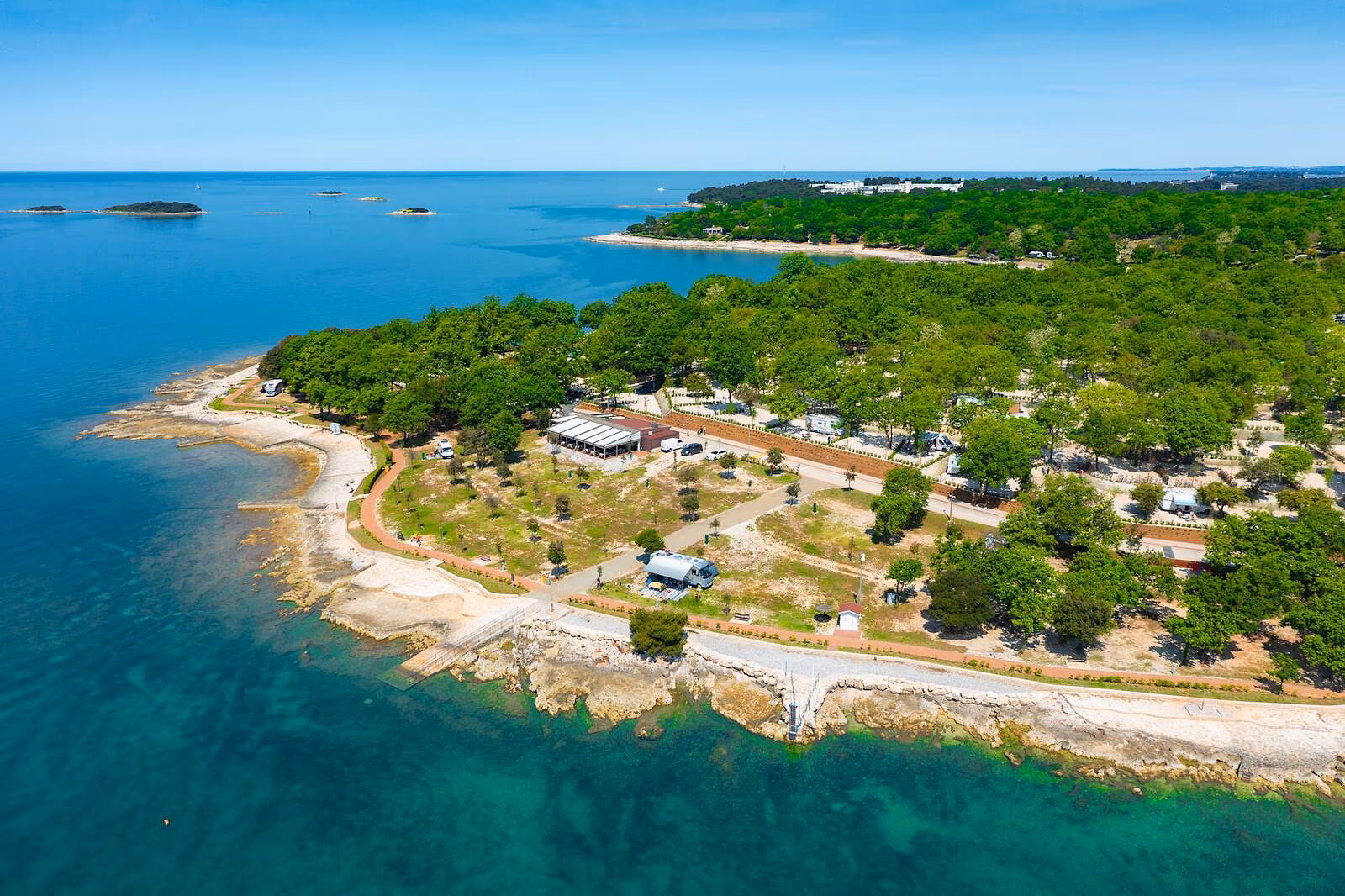 Luchtfoto van het groene schiereiland en de kustlijn van Camping Bijela Uvala