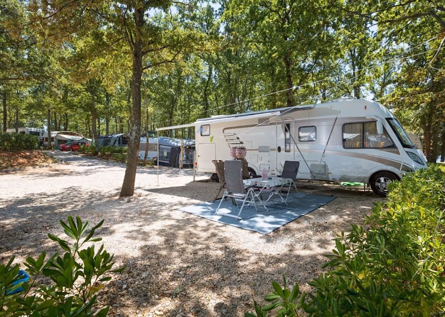 Superior staanplaats op Camping Bijela Uvala: camper met luifel op grind tussen eiken