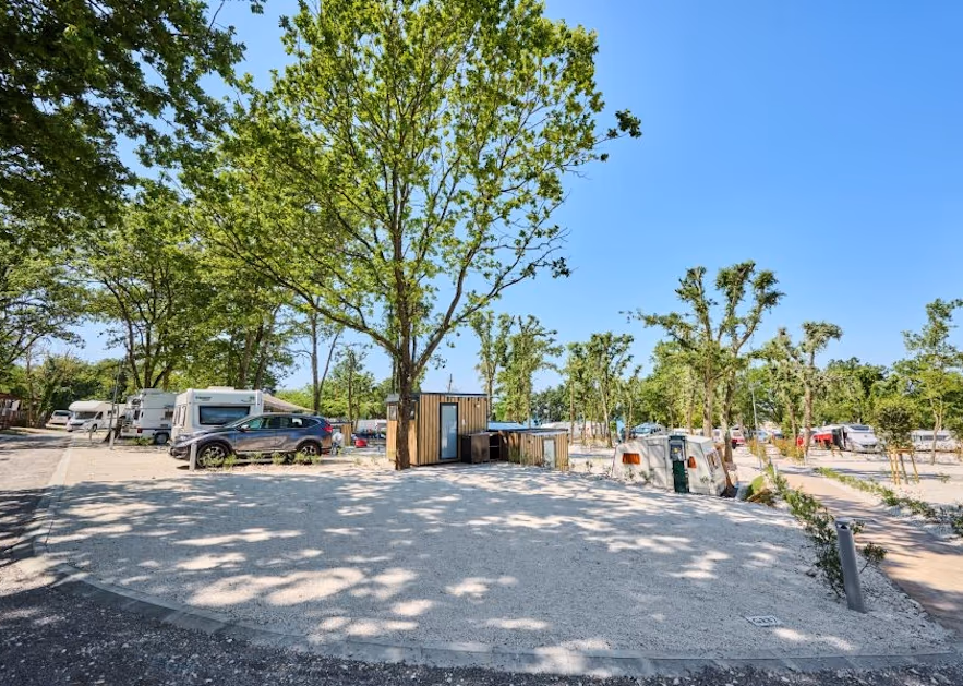 Lege staanplaats van Camping Bijela Uvala in Funtana met een houten eigen badkamerhuisje bij de boom