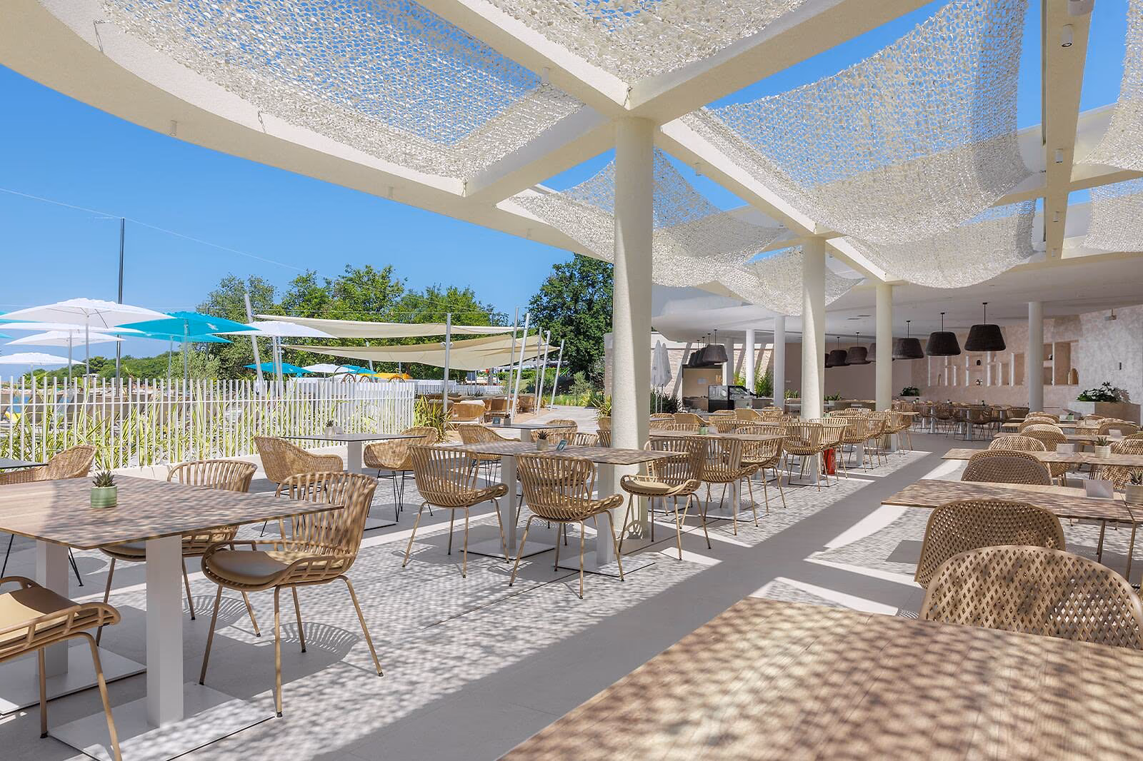 Licht overdekt terras van restaurant Vista Mare met rieten stoelen op Camping Bijela Uvala